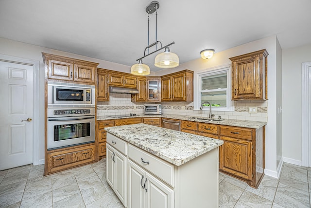 kitchen with backsplash, a kitchen island, appliances with stainless steel finishes, sink, and decorative light fixtures