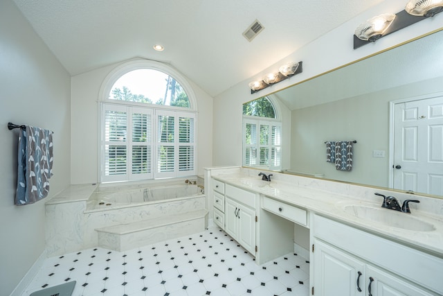 bathroom with a bathing tub, a textured ceiling, double vanity, tile patterned flooring, and lofted ceiling