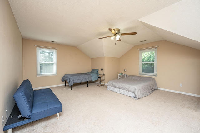 carpeted bedroom with ceiling fan, multiple windows, and vaulted ceiling