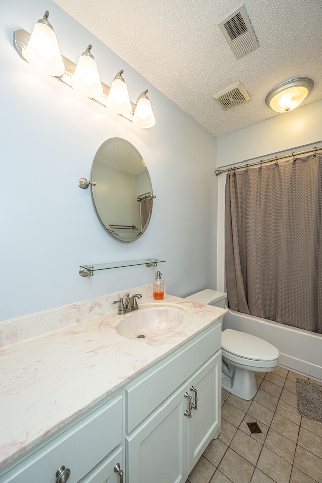 full bathroom featuring vanity, shower / bath combo with shower curtain, tile patterned floors, a textured ceiling, and toilet