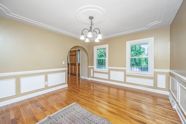 empty room featuring light wood-type flooring and an inviting chandelier