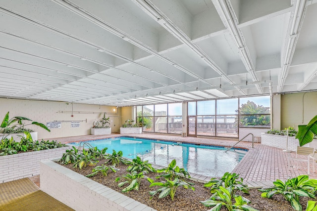 view of pool with glass enclosure and a patio