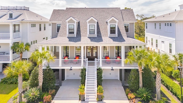 coastal inspired home featuring a garage and covered porch