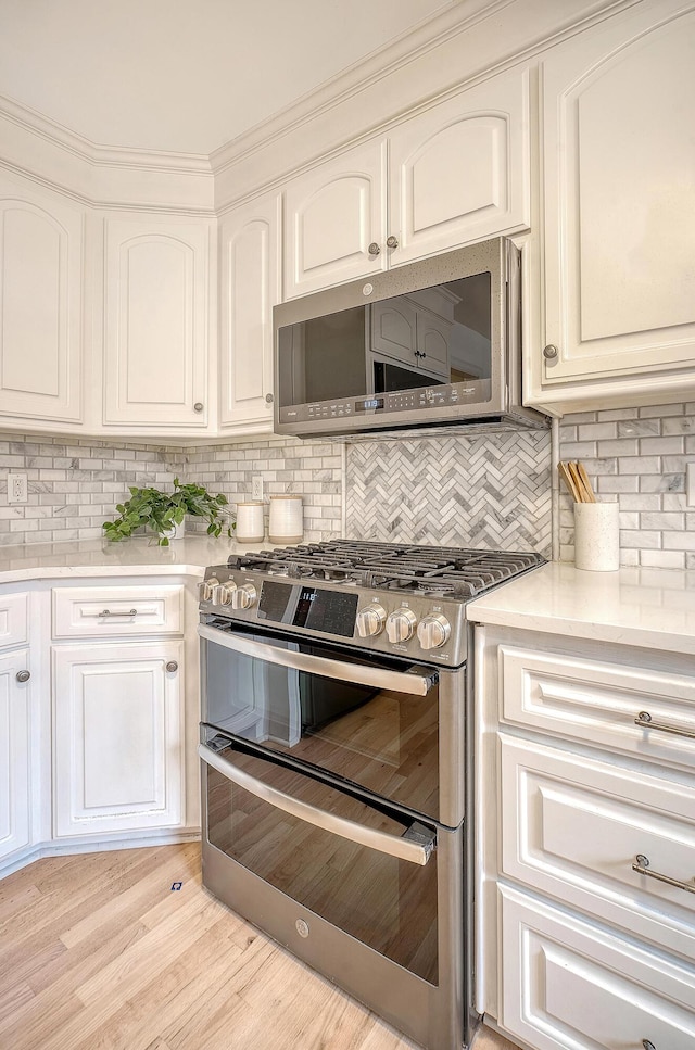 kitchen with decorative backsplash, light countertops, and appliances with stainless steel finishes