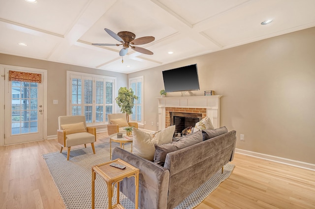 living room with baseboards, light wood-style flooring, coffered ceiling, and a ceiling fan