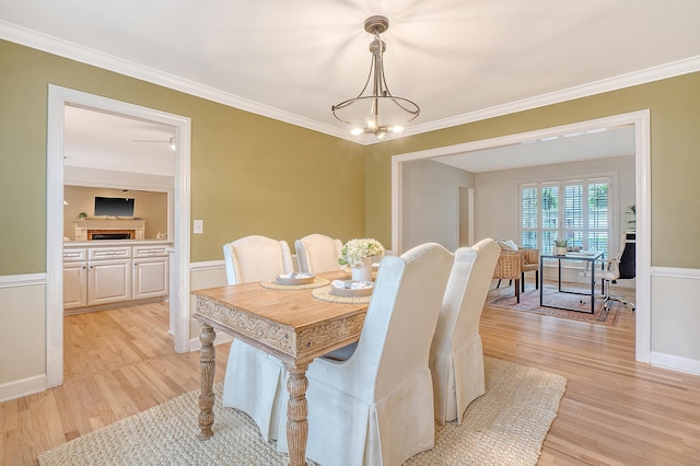 dining area featuring baseboards, crown molding, an inviting chandelier, and light wood-type flooring