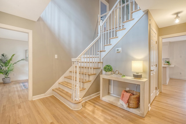 stairway with baseboards and wood finished floors