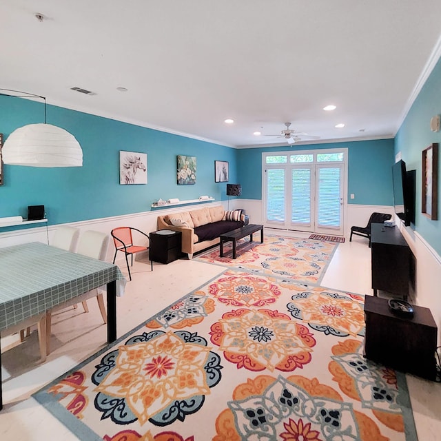 living room featuring ceiling fan and crown molding