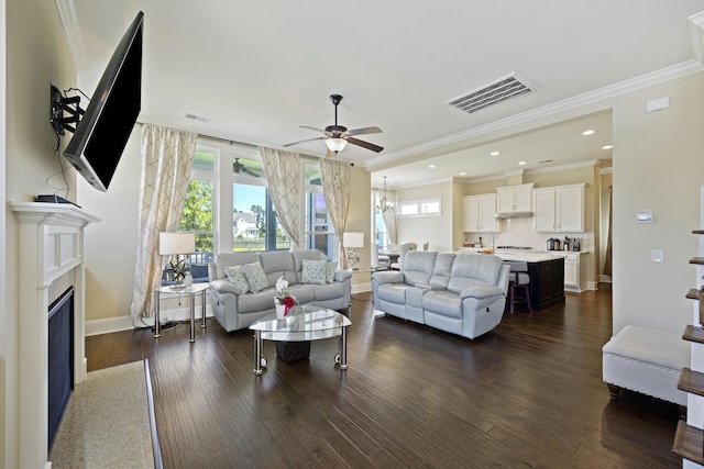 living room with dark hardwood / wood-style flooring, crown molding, and ceiling fan with notable chandelier