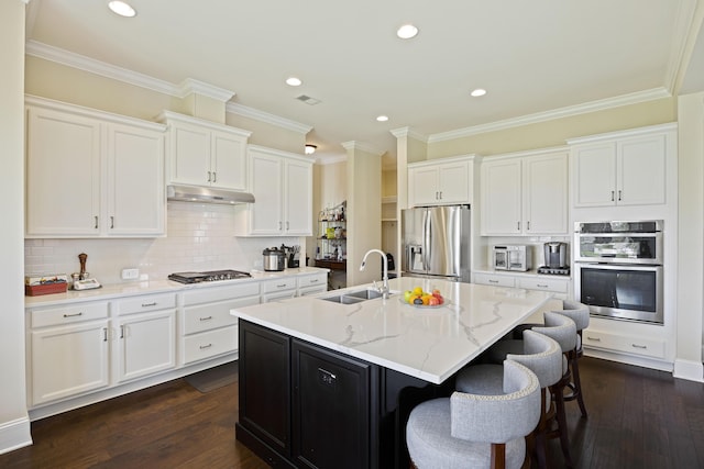 kitchen featuring white cabinetry, stainless steel appliances, an island with sink, sink, and dark hardwood / wood-style floors