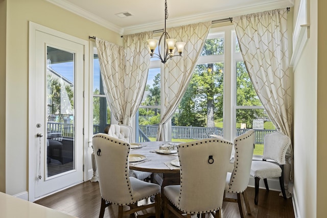 dining room with an inviting chandelier, ornamental molding, and dark hardwood / wood-style flooring