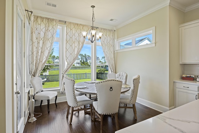 dining area featuring dark hardwood / wood-style floors, ornamental molding, and an inviting chandelier