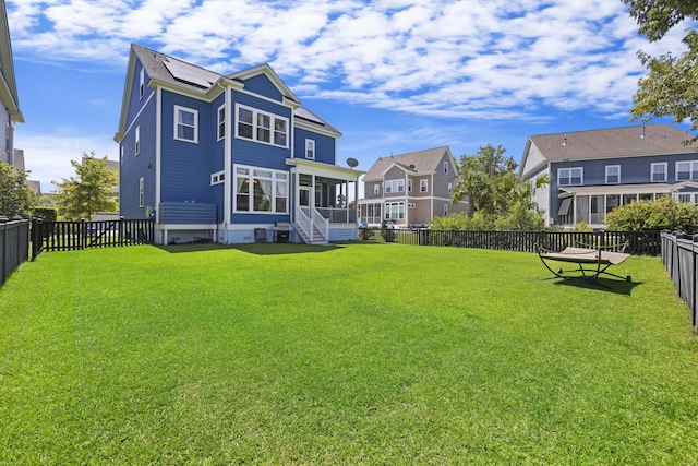 back of house with a yard and a sunroom