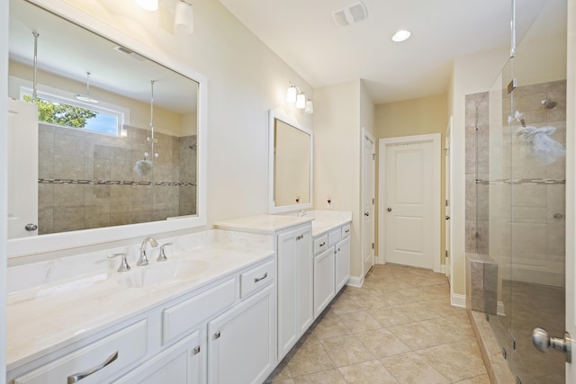 bathroom with vanity, tile patterned floors, and tiled shower