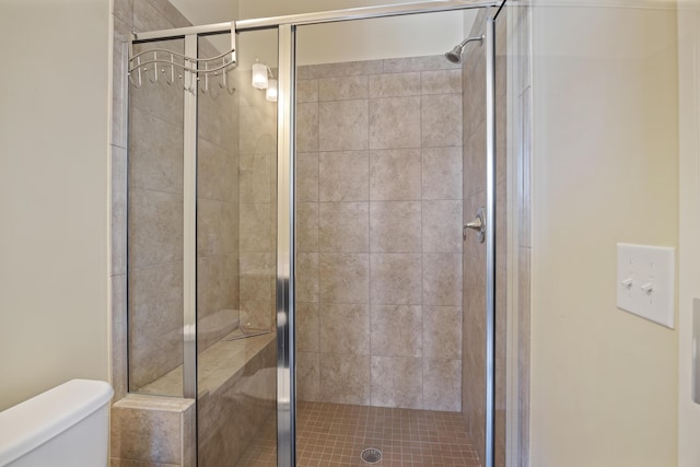 bathroom with toilet and an enclosed shower