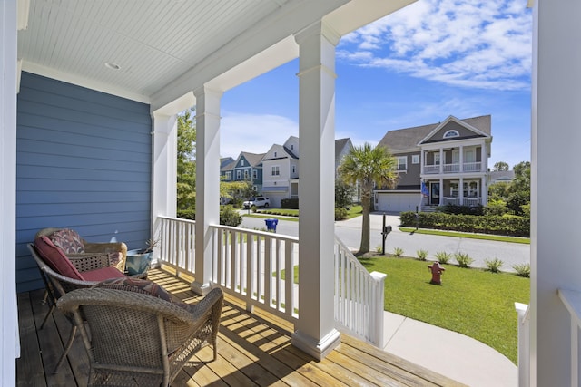 wooden deck featuring a lawn and a porch