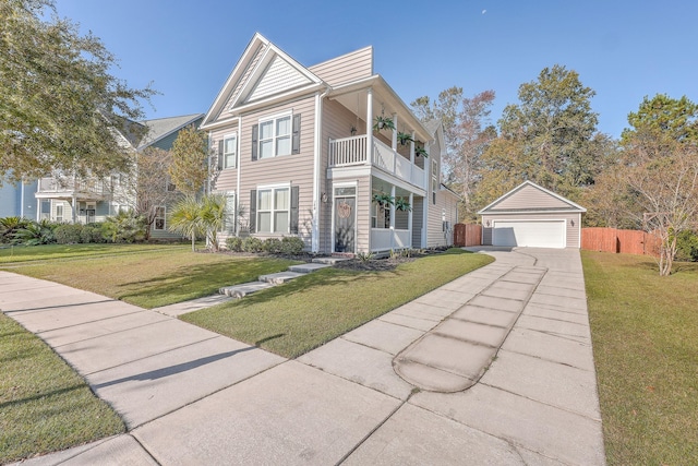 view of front of home featuring a front lawn, a balcony, an outbuilding, and a garage