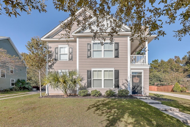 view of front of home with a balcony and a front yard