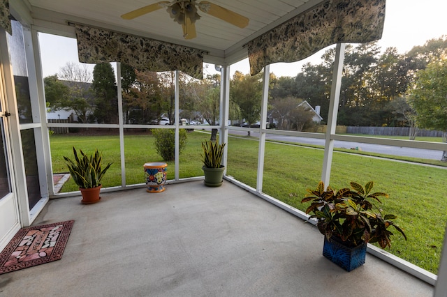 unfurnished sunroom with ceiling fan, wooden ceiling, and a healthy amount of sunlight