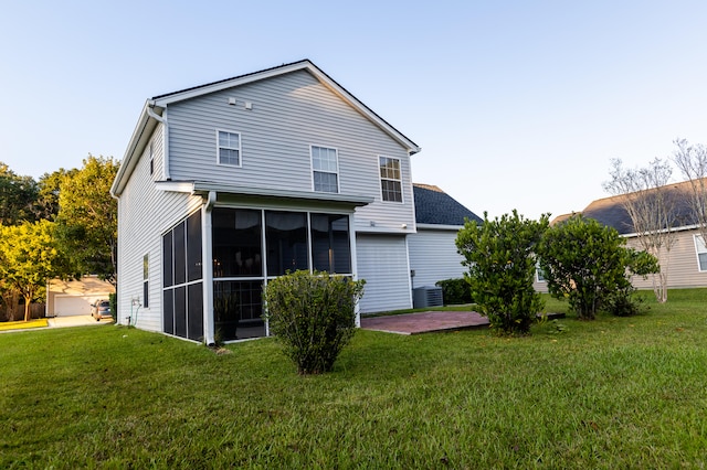 rear view of house with a lawn, central AC, a sunroom, and a patio