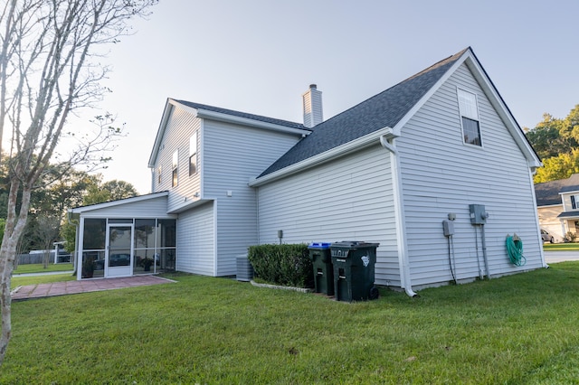 back of house with a yard, a sunroom, and a patio area