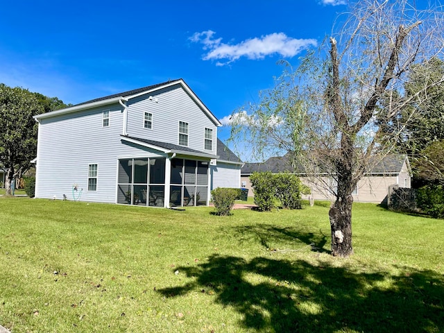 rear view of property with a lawn and a sunroom