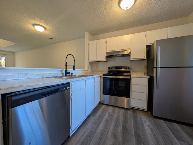 kitchen featuring sink, dark hardwood / wood-style flooring, a textured ceiling, white cabinets, and appliances with stainless steel finishes