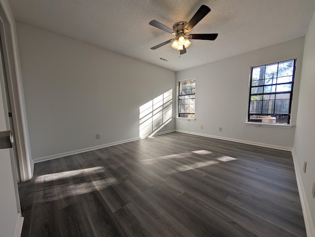 unfurnished room with plenty of natural light, ceiling fan, dark hardwood / wood-style flooring, and a textured ceiling