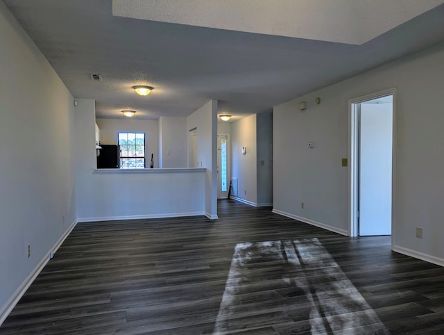 unfurnished room featuring a textured ceiling and dark wood-type flooring