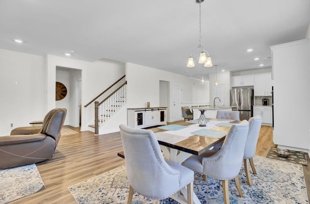 dining area featuring recessed lighting, stairway, and light wood-style flooring