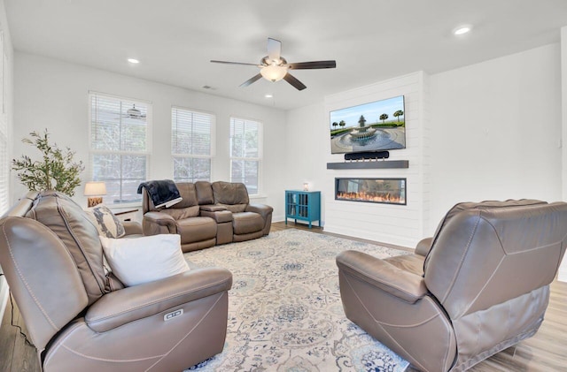 living room with a ceiling fan, recessed lighting, wood finished floors, and a large fireplace