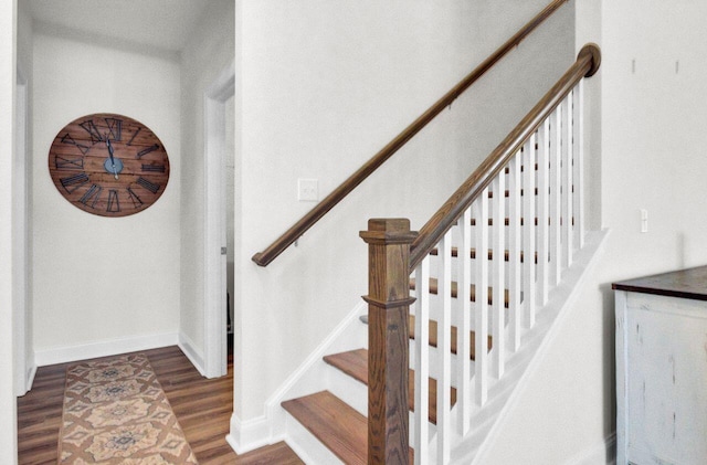 stairs featuring wood finished floors and baseboards