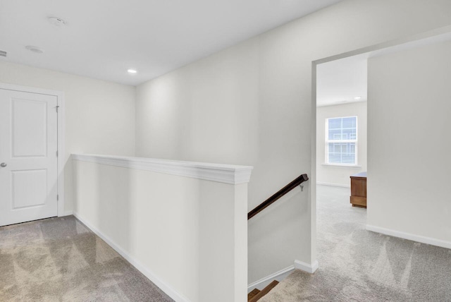 hall with an upstairs landing, recessed lighting, baseboards, and carpet