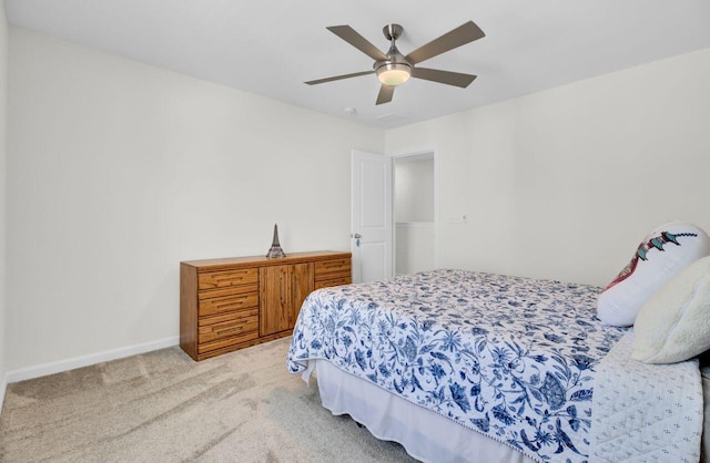 bedroom with a ceiling fan, light colored carpet, and baseboards