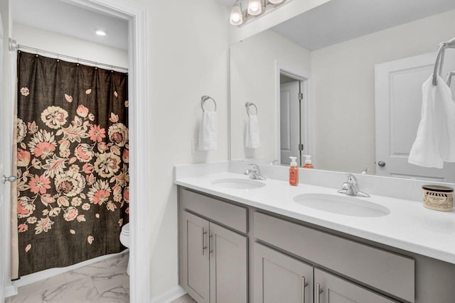 bathroom with a sink, toilet, marble finish floor, and double vanity