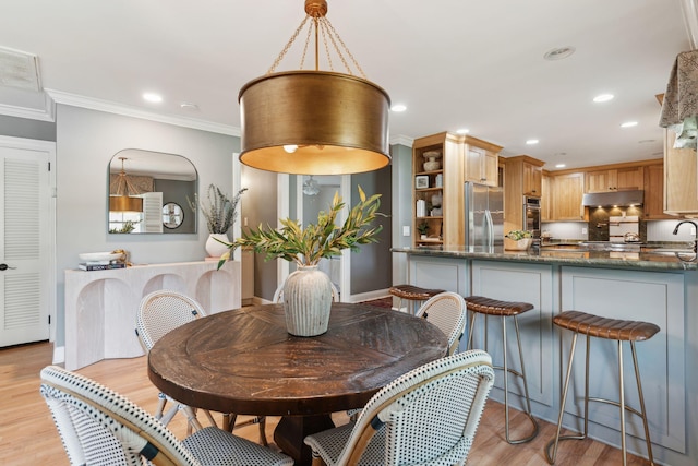 dining space featuring crown molding, recessed lighting, and light wood-style flooring
