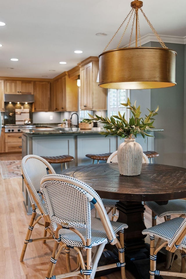 dining area with crown molding, recessed lighting, and light wood-type flooring