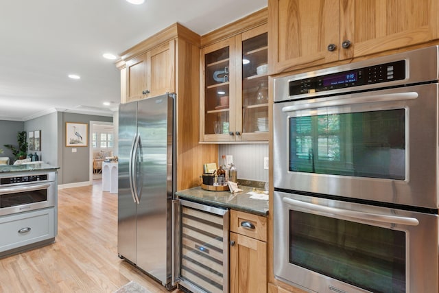 kitchen featuring beverage cooler, glass insert cabinets, crown molding, and stainless steel appliances