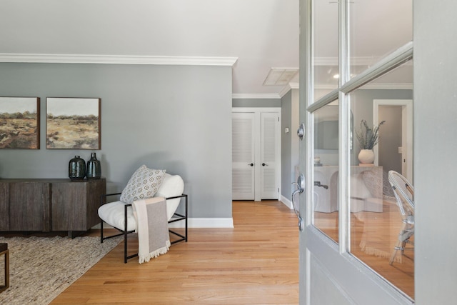 sitting room featuring crown molding, baseboards, and light wood-style floors