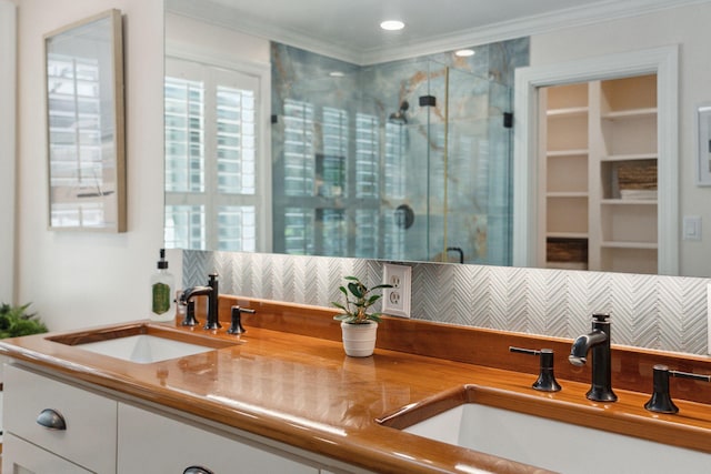 bathroom with a sink, decorative backsplash, ornamental molding, and a stall shower