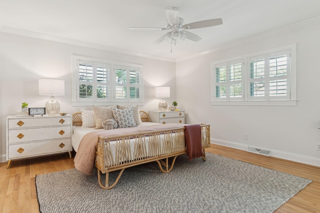 bedroom featuring visible vents, ornamental molding, baseboards, a ceiling fan, and light wood finished floors