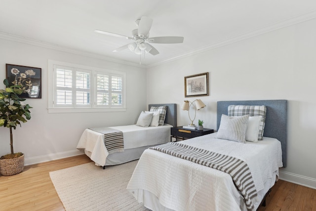 bedroom featuring crown molding, baseboards, ceiling fan, and wood finished floors