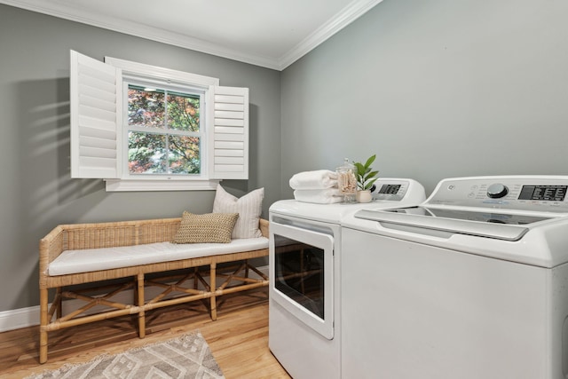 laundry area featuring independent washer and dryer, crown molding, laundry area, light wood-style flooring, and baseboards