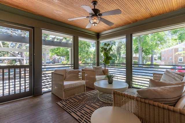 sunroom featuring ceiling fan, ornamental molding, and hardwood / wood-style flooring