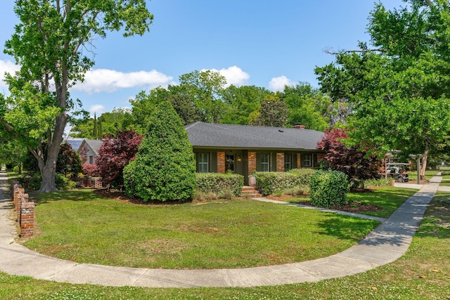 view of front of home with a chimney and a front yard