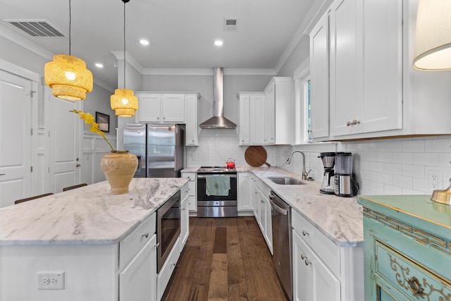 129 Martins Point Dr, Wando, SC 29492 - kitchen featuring stainless steel appliances, wall chimney range hood, white cabinets, ornamental molding, and a center island