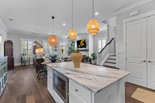 129 Martins Point Dr, Wando, SC 29492 - kitchen with stainless steel microwave, crown molding, recessed lighting, white cabinets, and dark wood finished floors