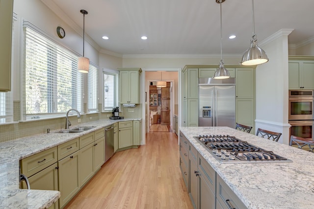 kitchen featuring appliances with stainless steel finishes, ornamental molding, a sink, light stone countertops, and backsplash