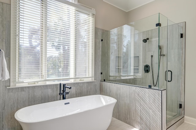 bathroom featuring a soaking tub, a shower stall, and a sink