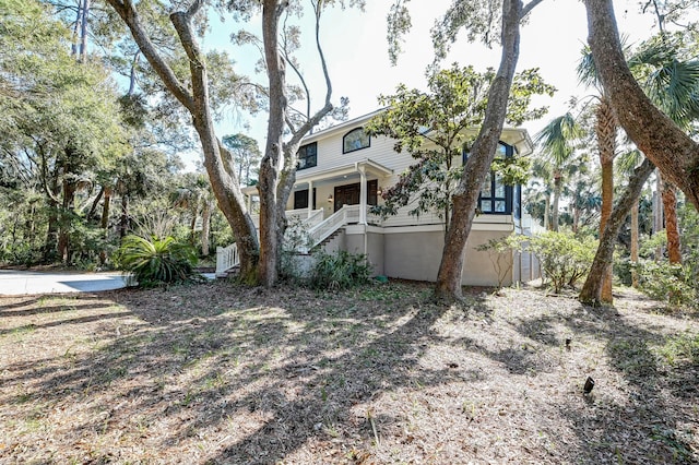 exterior space featuring covered porch and stairway